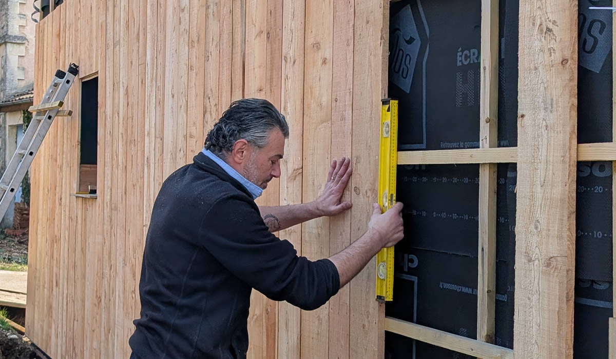 Serge USTUN posant un bardage mélèze